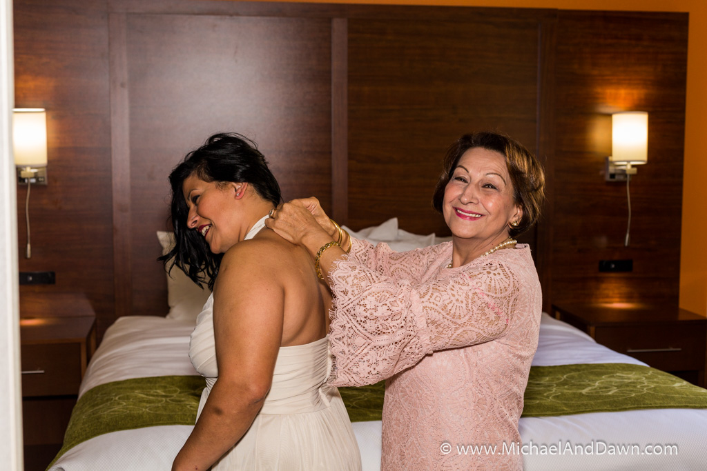 picture of mother helping daughter get dressed for wedding