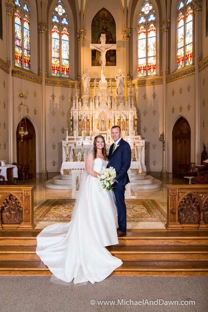 picture of bride and groom in front of fancy alter